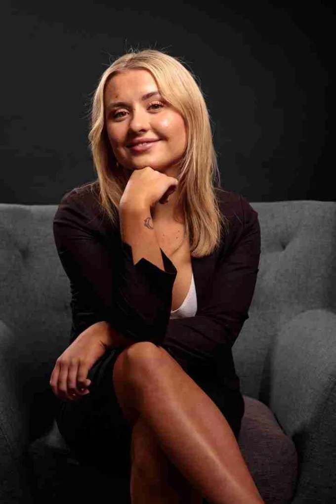 A professional portrait against a dark background